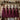 Cinque grembiuli bordeaux Team Primitivo, Nebbiolo, Bollicine, Orange e Sangiovese appesi in una cucina rustica - Vinclick